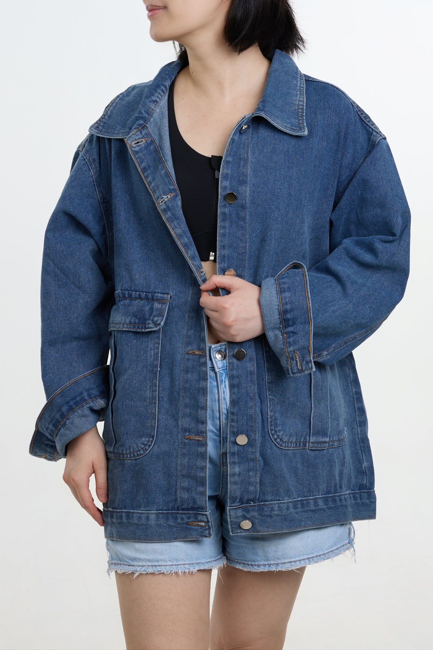 Person wearing a blue denim jacket on a white background