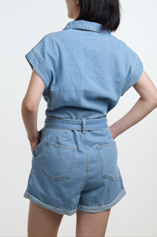Person wearing a light blue denim outfit on a white background