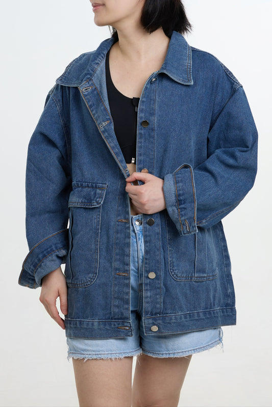 Person wearing a blue denim jacket on a white background